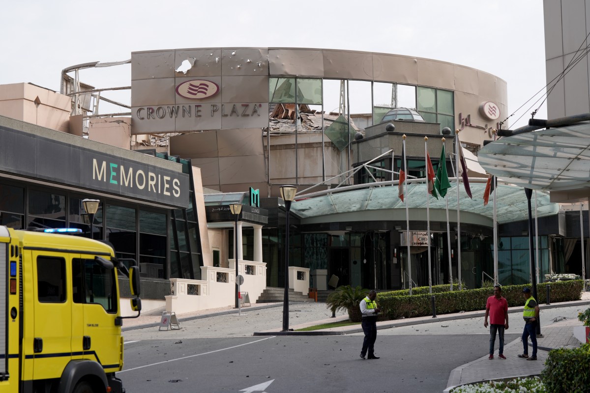Security and civil defence workers stand outside the damaged Crown Plaza hotel, following an Iranian military strike, in Manama on March 1, 2026.